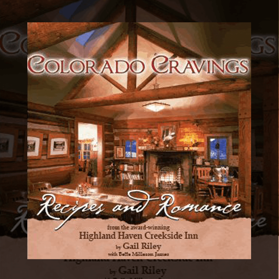 Cover of "Colorado Cravings: Recipes and Romance" featuring a cozy log cabin interior with a fireplace.