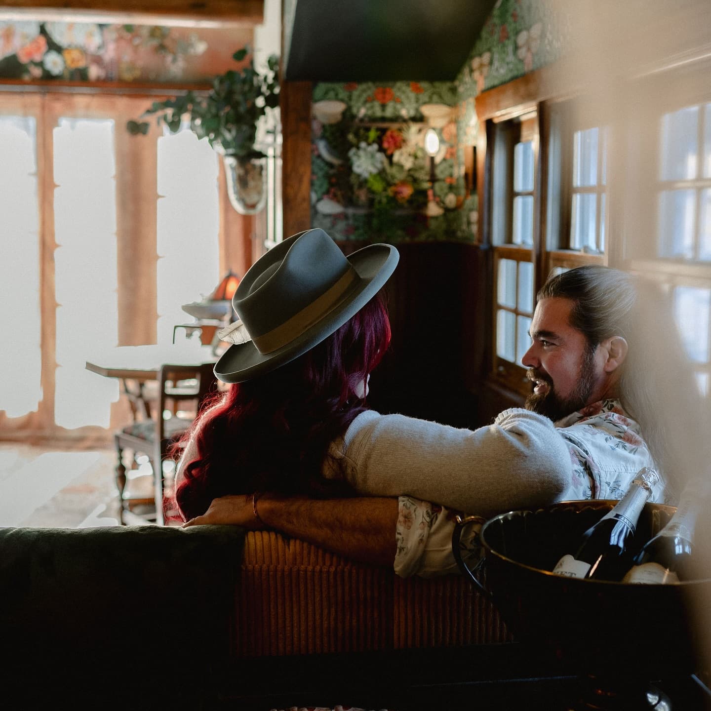 A couple shares a cozy moment in a warmly decorated interior.