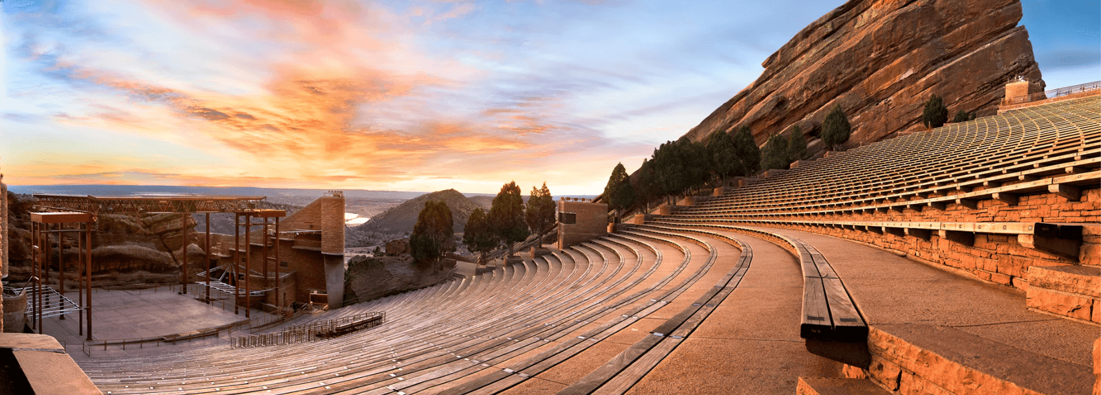 A scenic view of Red Rocks Amphitheatre, showcasing its seating and rocky backdrop during sunset.